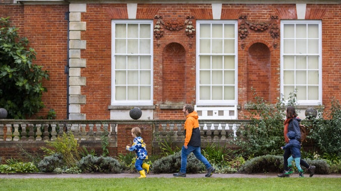 Family walking along the path in front of the house at Hatchlands Park